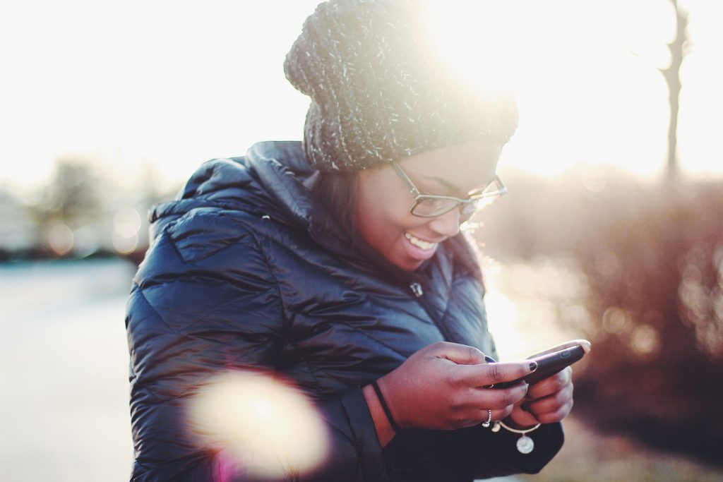 woman in hat looking at cell phone